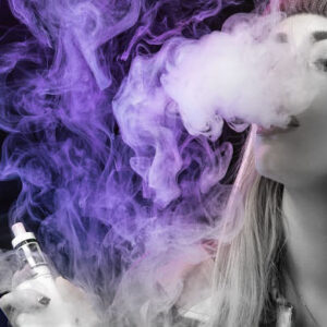 mulher de cabelo loira, com toca na cabeça sobrando fumaça segurando vape recarregavel