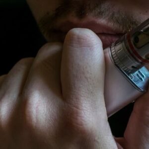 homem pensativo segurando um aparelho de cigarro eletrônico