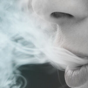 mulher soltando vapor após fumar cigarro eletrônico