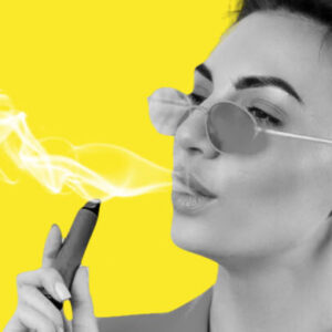 mulher de óculos soltando vapor com um cigarro eletrônico na mão