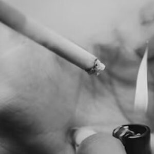 pessoa acendendo cigarro com um isqueiro