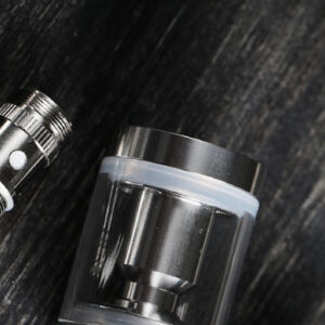 foto preta e branca com acessórios de vape sobre uma mesa de madeira