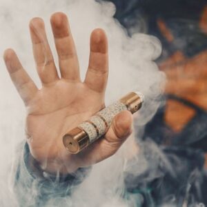 mão segurando cigarro eletrônico em meio ao vapor gerado pelo vape.