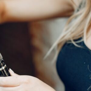 mulher loira abastecendo o seu cigarro eletrônico