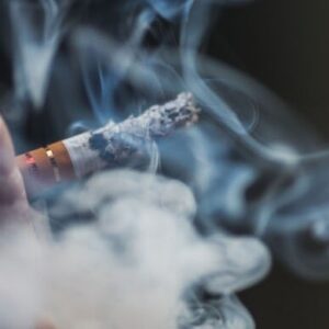 homem fumando cigarro com fumaça em volta